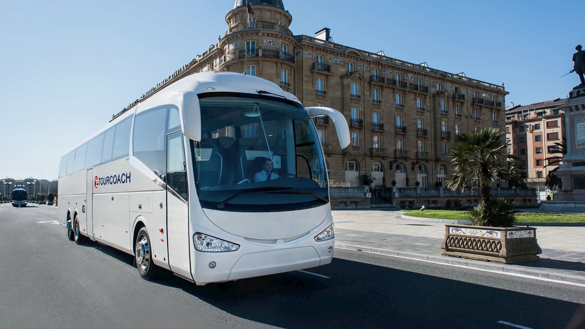 TourCoach bus in front of a tall building
